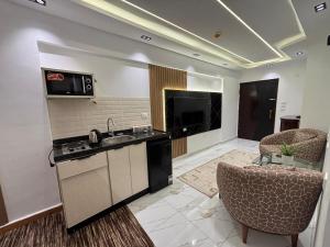 a kitchen with a sink and two chairs at Royal Suite Hotel - Nasr City, Cairo in Cairo