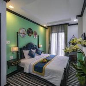 a bedroom with a large bed with a green wall at Belvilla Near Tan Son Nhat International Airport - Formerly Vyvy Hotel in Ho Chi Minh City +16 photos