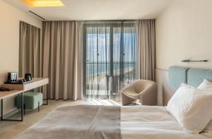 a hotel room with a bed and a window at GRIFID Noa - Premium Ultra All Inclusive in Golden Sands