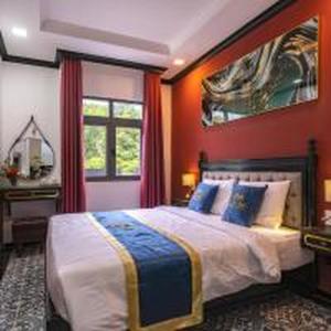 a bedroom with a large bed with an orange wall at Belvilla Near Tan Son Nhat International Airport - Formerly Vyvy Hotel in Ho Chi Minh City