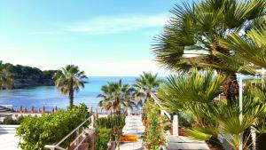 a view of the ocean from a resort with palm trees at Phalanthos B&B in Leporano
