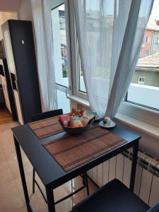a table with a bowl of food on it in front of a window at Simply The Best - Vitosha blvd in Sofia
