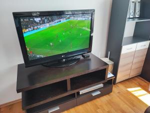 a television on a stand with a soccer game on it at Simply The Best - Vitosha blvd in Sofia