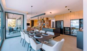 a dining room and kitchen with a table and chairs at Villa Blue Sunset in Brsečine