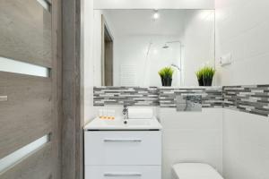 a white bathroom with a sink and a toilet at Family Apartment Puck Closeto the Sea by Noclegi Renters in Puck
