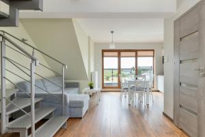 a living room with a staircase and a table and chairs at Family Apartment Puck Closeto the Sea by Noclegi Renters in Puck +19 photos