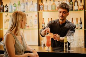 a man and a woman sitting at a bar making a drink at Hotel Món Sant Benet in Sant Fruitos de Bages +49 photos