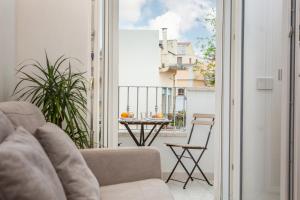 a living room with a couch and a table on a balcony at Madau's House Exclusive Apartments in Olbia