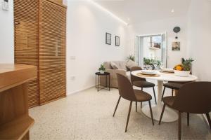 a kitchen and living room with a table and chairs at Madau's House Apartments & Suites in Olbia