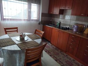 a kitchen with a table and a table and chairs at Hiža Guesthouse in Sarajevo