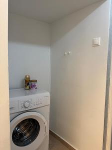 a white washer and dryer in a small room at Nikistratos Cozy Apartment in Néa Alikarnassós