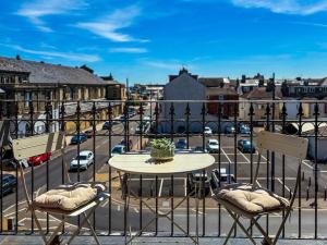 a table and chairs on a balcony with a street at Euston Road - Beach Apartment 4 in Great Yarmouth
