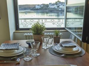 stół z płytami i kieliszkami oraz widok na wodę w obiekcie Studio moderne au cœur de Sauzon avec kitchenette et Wi-Fi - FR-1-418-227 w mieście Sauzon