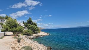 a view of the ocean from a rocky shore at Apartments Nada in Trogir