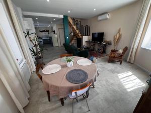 a living room with a table with chairs and a living room at La Pause d'Antan 