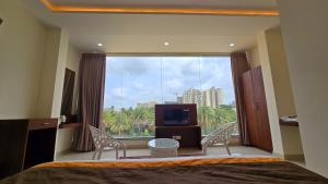 a bedroom with a large window with a view of a city at LakeWood Gardenia Boutique Hotel in Bengaluru