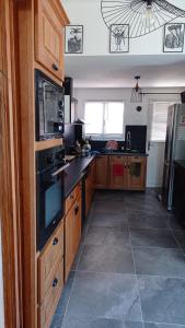 a kitchen with wooden cabinets and a black counter top at St ybars chez Annick et Alain in Saint-Ybars +10 photos