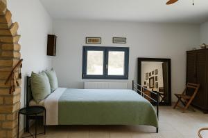 a bedroom with a bed and a window at Pefko Salty Studio in Vathí
