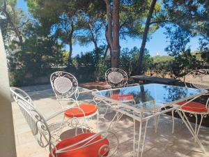 a glass table and chairs on a patio at Pefko Salty Studio in Vathí