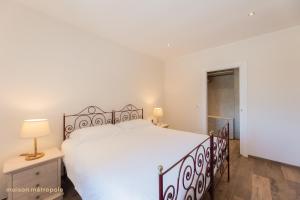 a bedroom with a large white bed and a lamp at Parco della Mandria - La Falchetta House in Robassomero