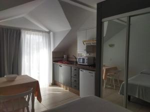a kitchen with a table and a kitchen with a microwave at Estudio con Piscina en Puerto de la Cruz in Puerto de la Cruz +3 photos