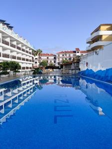 a large pool of blue water next to a building at Estudio con Piscina en Puerto de la Cruz in Puerto de la Cruz