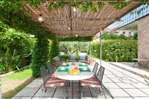 a patio with a table and chairs under a pergola at Stelle Galeotte Exclusive Holiday Home in Fondi +56 photos