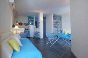 uma sala de estar com um sofá azul e uma mesa em La finestra sul mare em Cagliari