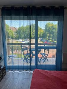 a room with a large window with a table and chairs at Résidence les goélettes studio l escale in Houlgate