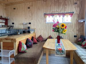 een keuken met een tafel met daarop een vaas met bloemen bij CABAÑA ORO RAYADO PUERTO MONtt in Puerto Montt +10 foto's