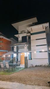 a group of chairs in front of a building at night at 2 Storey Family House in Casa Verde Mati City in Mati