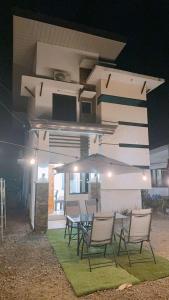 a group of chairs and a table in front of a building at 2 Storey Family House in Casa Verde Mati City in Mati