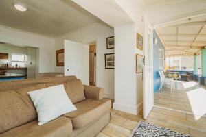 a living room with a couch and a kitchen at Silver Spray Beach Accommodation in Victoria Bay