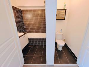 a bathroom with a toilet and a sink and a tub at Saint Ruth - Apartment for 2 with private parking in Lille