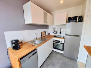 a small kitchen with a sink and a refrigerator at Saint Ruth - Apartment for 2 with private parking in Lille +1 photo
