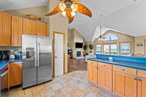 a kitchen with a refrigerator and a ceiling fan at By the See in Waves