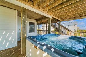 a hot tub on the deck of a house at By the See in Waves