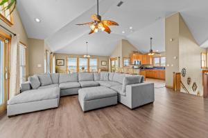 a living room with a gray couch and a kitchen at By the See in Waves