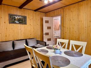 a dining room with a table and chairs and a couch at Dimira Котедж з басейном in Slavske