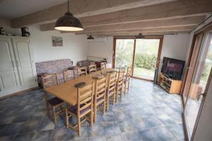 a dining room with a table and chairs and a television at Gites au Cœur de la Nature, Piscine et Vue sur le Lac du Salagou in Le Puech