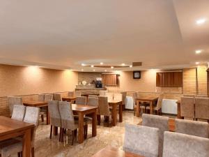 a dining room with wooden tables and chairs at Hotel Iceberg in Bakuriani