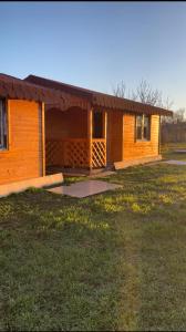 a small cabin with a grass field in front of it at Camping mery in Murighiol
