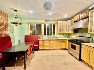 a kitchen with wooden cabinets and a table with red chairs at MOTEL House in Newark