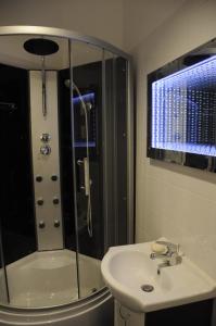 y baño con ducha y lavabo blanco. en Apartament Bogusławskiego, en Cracovia