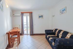 a living room with a couch and a table at Kalimera Hotel in Poros
