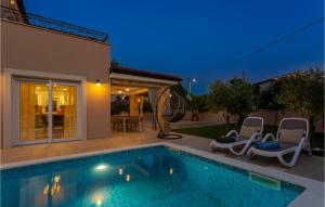 a swimming pool with two chairs and a house at Beautiful Home In Pinezici With Kitchen in Pinezici +36 photos