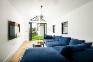 Somerford KeynesにあるInfinity Lodge ML05 Lower Mill The Cotswoldsの青いソファとテーブルのあるリビングルーム