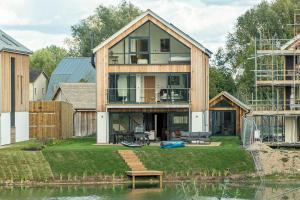 Somerford KeynesにあるInfinity Lodge ML05 Lower Mill The Cotswoldsの水の上に家が建てられている
