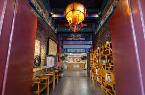 a hallway with chairs and a chandelier in a building at East Sacred Hotel-Very close to the Drum Tower,The Lama Temple,Houhai Bar Street,Nanluoguxiang,Tiananmen Square and the Forbidden City, and the subway st ation is also very close in Beijing