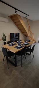 a dining room table with chairs and a staircase at Na Skraju - Pogorzelica - Domki Rekreacyjne lokal D in Pogorzelica
